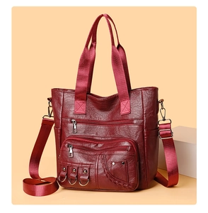 Detail of vintage burgundy tote with multi-zipper pockets and soft PU leather texture