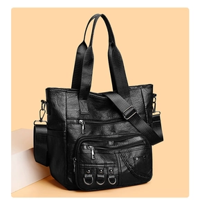 Close-up of black retro tote bag showing wrinkled leather texture and zipper pockets