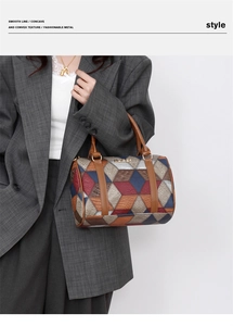 Detail of geometric patchwork Boston bag with crocodile pattern and golden hardware