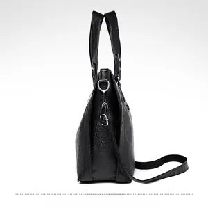 Détail du sac à bandoulière en cuir PU noir montrant la texture grainée et les boucles argent