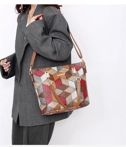 Detailed side view of tote bag with geometric color-block leather and adjustable strap