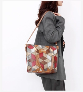 Detail of color-block geometric 3D cube pattern on leather tote bag with gold hardware