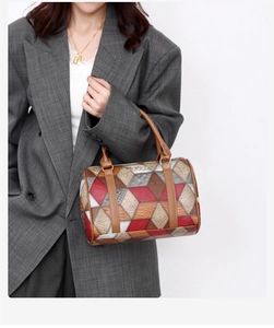 Detail view of geometric patchwork Boston tote bag paired with a grey plaid blazer