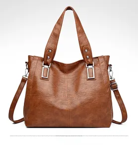 Détail d'un grand sac cabas marron jaune avec coutures matelassées et boucle argent