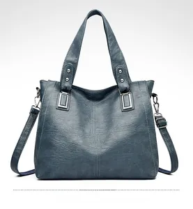 Détail du sac cabas bleu lac montrant le cuir grainé et les coutures croisées fines