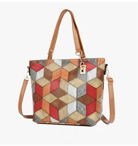 Macro shot of geometric color-block tote featuring faux crocodile embossed leather details