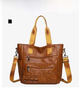 Front detail of vintage brown leather tote bag featuring multiple zip pockets and wide strap