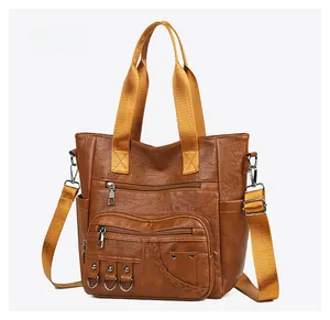 Detail of caramel brown tote bag with lychee texture and yellow fabric handles