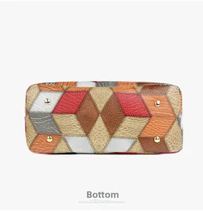 Detail view of multi-textured leather tote bag bottom with four gold protective metal feet
