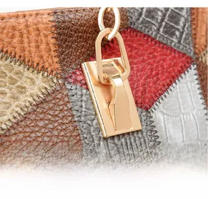 Macro detail of multicolored contrast leather tote with crocodile texture and gold hardware