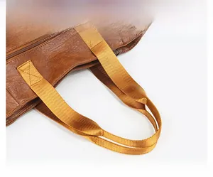 Close-up of brown PU leather tote bag with thick yellow nylon woven handles and zipper