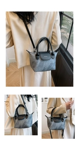 Détail du sac seau bandoulière moyen avec corps gris texturé et lanières en cuir noir