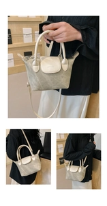 Vues détaillées du sac seau gris texturé avec poignées et bandoulière blanc cassé