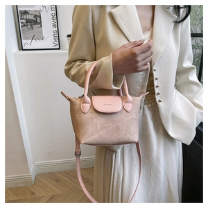 Détail du sac seau bicolore rose et beige avec texture plissée et bandoulière réglable