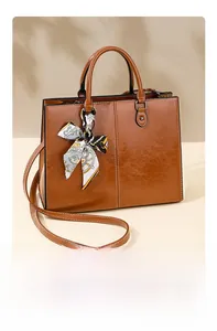 Detail of brown wax leather tote bag with decorative silk scarf and adjustable strap