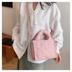 Detailansicht der rosa gesteppten Puffer-Tasche mit Blumennaht und breitem Gurt