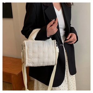 Detail der cremefarbenen Stepptasche mit Blumenstickerei und verstellbarem Riemen