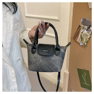 Détail de la texture délavée et de la poignée en cuir de ce petit sac seau à la mode