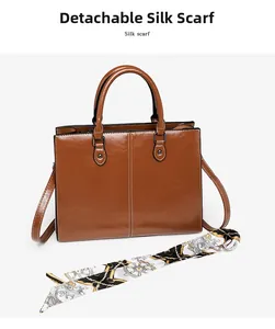 Detail of brown oil-wax leather tote with white stitching and decorative silk scarf
