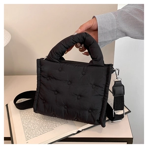Detailansicht der schwarzen gesteppten Puffer-Tasche mit breitem verstellbarem Gurt