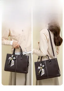 Detail of dark brown oil wax leather tote bag with decorative silk scarf and dual carry style