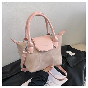 Détail du sac seau rose et beige avec logo ZHGNMA gaufré et fermeture éclair métallique