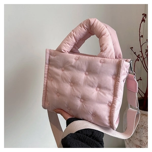 Detail der rosa gesteppten Mini-Umhängetasche mit weicher Daunenfüllung und Stickmuster