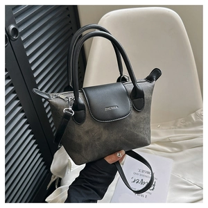 Détail du sac à main en tissu gris délavé avec rabat en cuir noir et boucle argentée