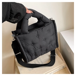 Detail der schwarzen gesteppten Daunenhandtasche mit gepolsterten Griffen und Gurt