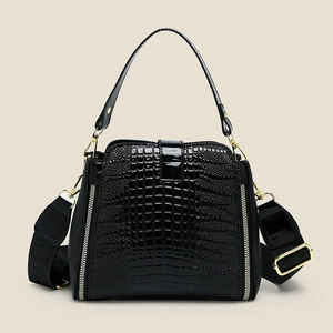 Elegant black crocodile-patterned handbag with golden hardware and wide crossbody strap