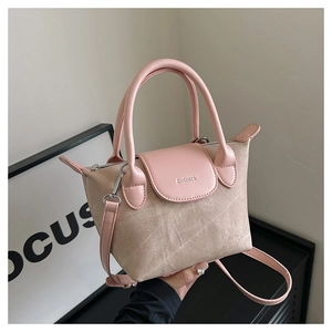 Détail du sac seau chic en tissu beige avec poignée en cuir rose et logo de marque