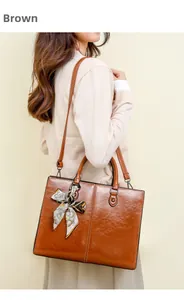 Brown oil wax leather tote bag with printed silk scarf and adjustable strap shown on model