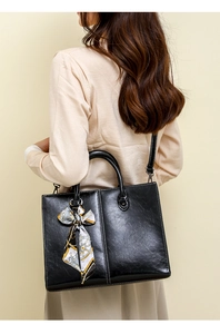 Detail of oil wax leather tote bag with white contrast stitching and printed silk scarf