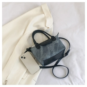 Vue détaillée du sac seau en denim et cuir avec smartphone pour taille de référence