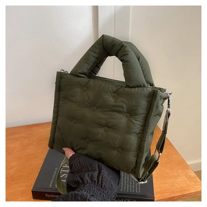 Detail der armee-grünen gesteppten Puffer-Minitasche mit gepolstertem Griff und Textur