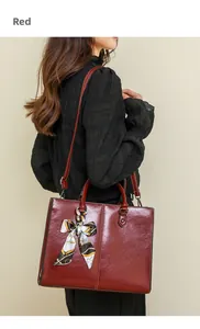 Detailed side view of deep red oil wax leather tote bag with printed silk scarf accent