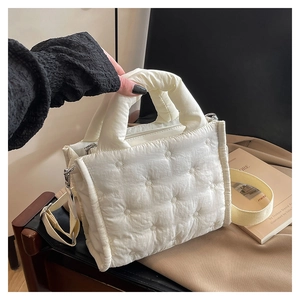 Detail der weißen gesteppten Nylon-Handtasche mit Polstergriff und Schultergurt