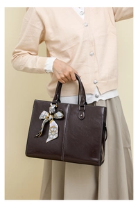 Close-up of deep brown wax leather tote bag with elegant printed silk scarf detail