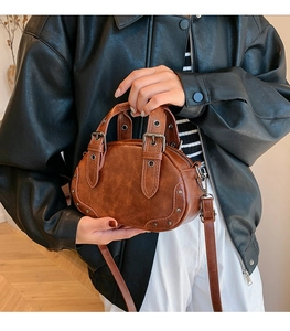 Detail of vintage brown bowling bag featuring retro studs and premium leather texture