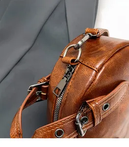 Macro detail of retro brown leather bag with brushed metal zipper and studded shoulder strap