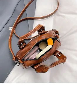 Interior view of brown oiled leather bag showing spacious compartment with cosmetics