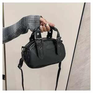 Detailed view of the matte black bowling bag featuring silver rivets and a long shoulder strap