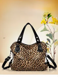 Close-up of leopard print tote bag with black leather straps and silver metal rivets