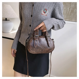 Detail of vintage brown leather bowling bag with silver buckles and rivets on side