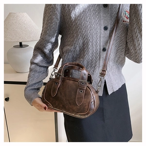 Close-up of vintage brown bowling bag featuring oil wax leather and metal rivet details