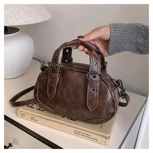 Close-up of vintage brown bowling bag with stud details and adjustable leather straps