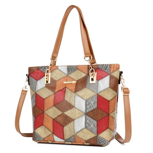 Large geometric patchwork tote bag with red and brown leather patterns and shoulder strap