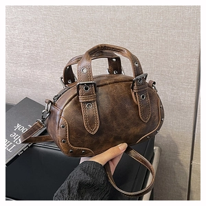 Detailed close-up of brown vintage bowling bag with metallic rivets and textured finish