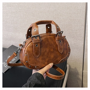 Close-up of vintage brown oil wax leather bag with silver rivets and metal hardware