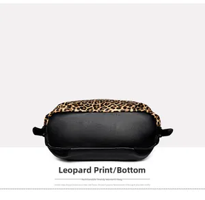 Close-up of leopard print fabric and black lychee grain leather bottom on a tote bag
